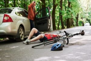 Injured cyclist on roadside after bicycle accident with damaged bike in Alpharetta Georgia