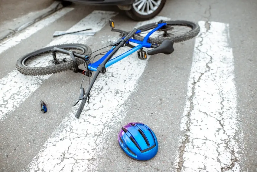 Damaged bicycle helmet and crashed bike showing severity of bicycle accident injuries