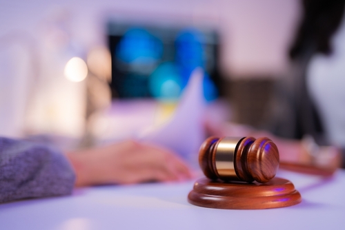 A personal injury lawyer at a table and a gavel helping a victim through a negligence in personal injury claim for a settlement.