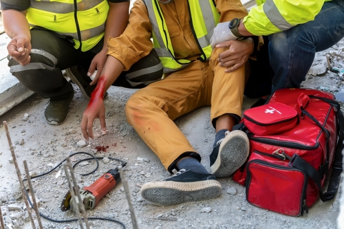 Construction worker on the ground bleeding due to a work place accident outside and now his looking to file a negligence in personal injury claim.
