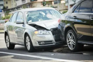 A silver car crashing into a black car causing vehicle damage and victim is now seeking help from a car accident lawyer to recover money for damages.